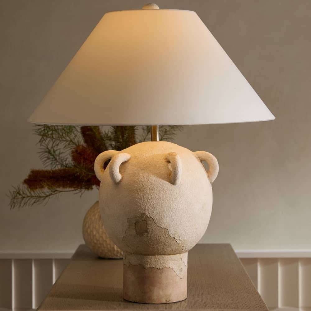 Lamp with a bear-shaped base on a table against a neutral wall.