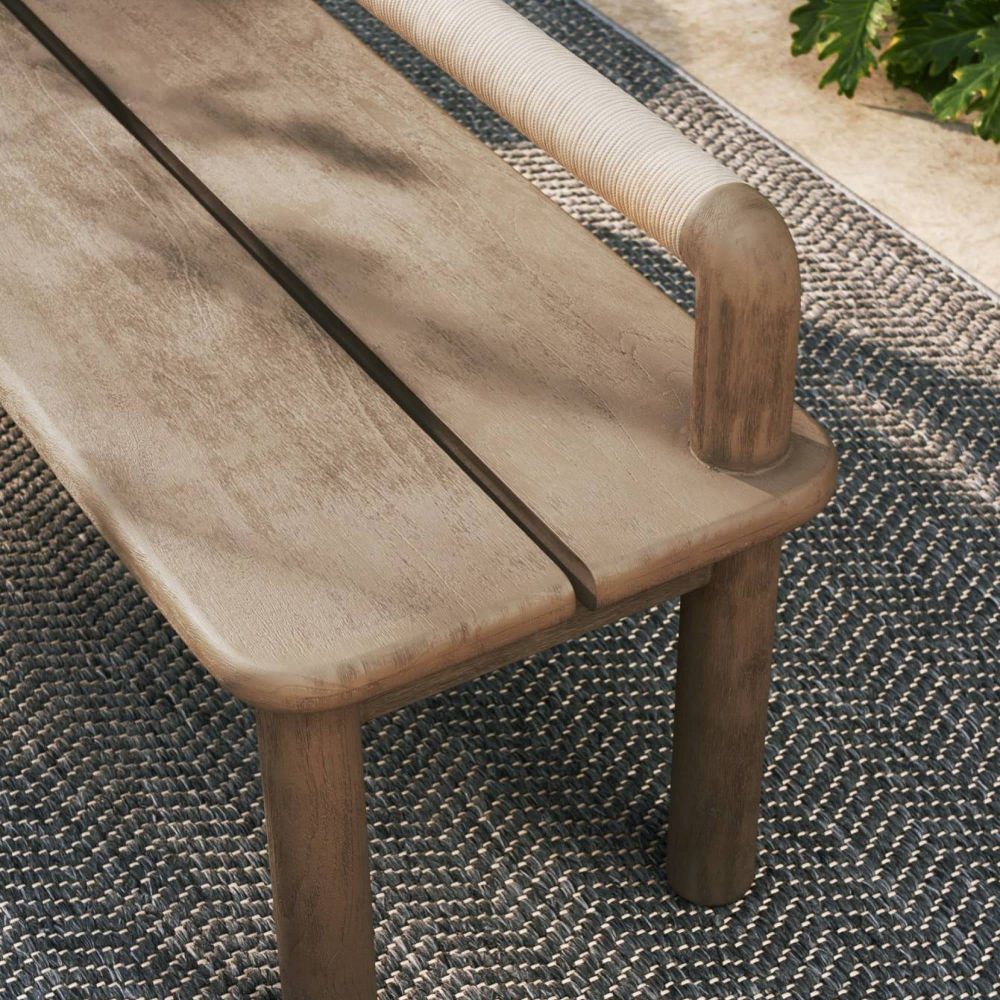 Wooden bench with a textured surface on a woven mat