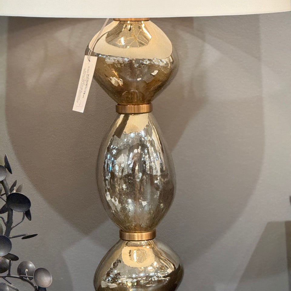 Decorative lamp with gold and glass design on a dark surface.