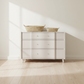White dresser with two woven baskets on top in a minimalistic room. (essery 48 gray)