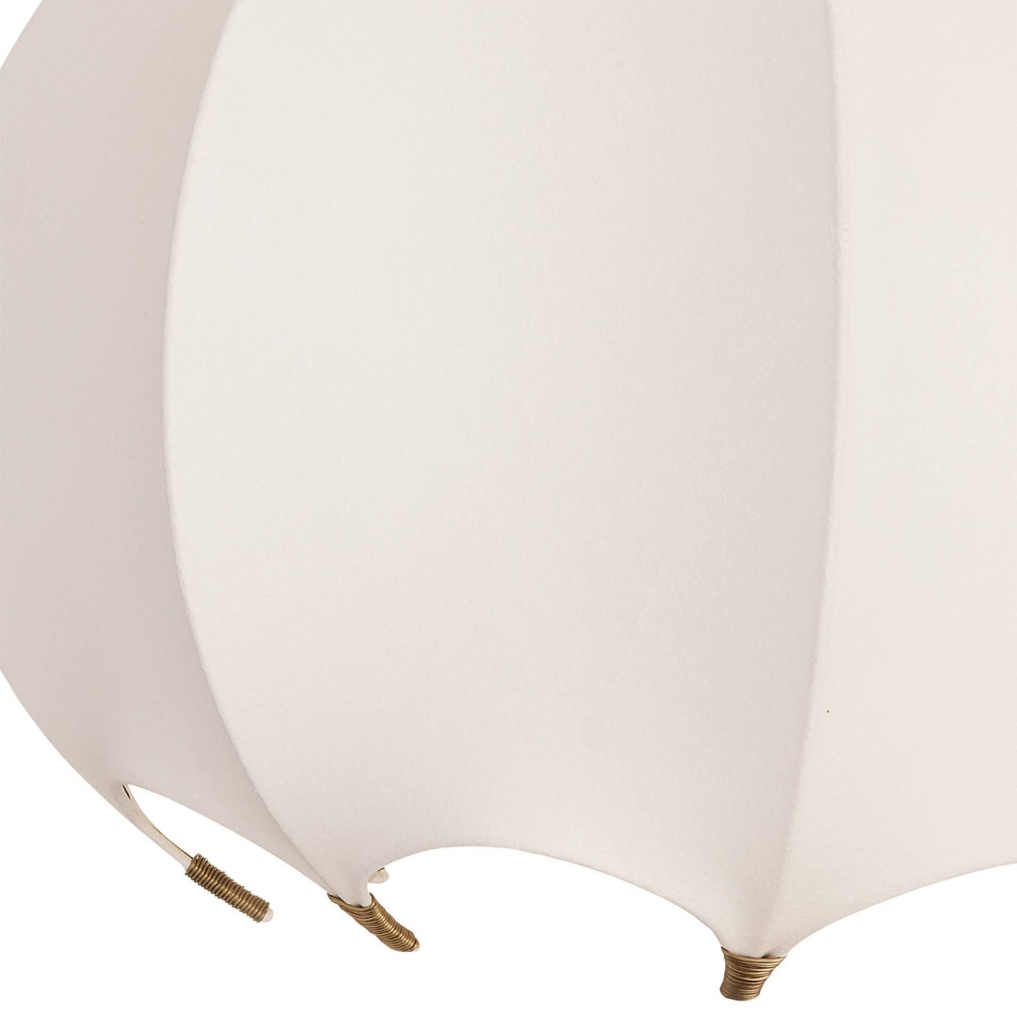 Close-up of a white scalloped lampshade with gold fixtures on a white background