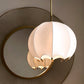 Modern ceiling light fixture with white and gold design on a neutral background