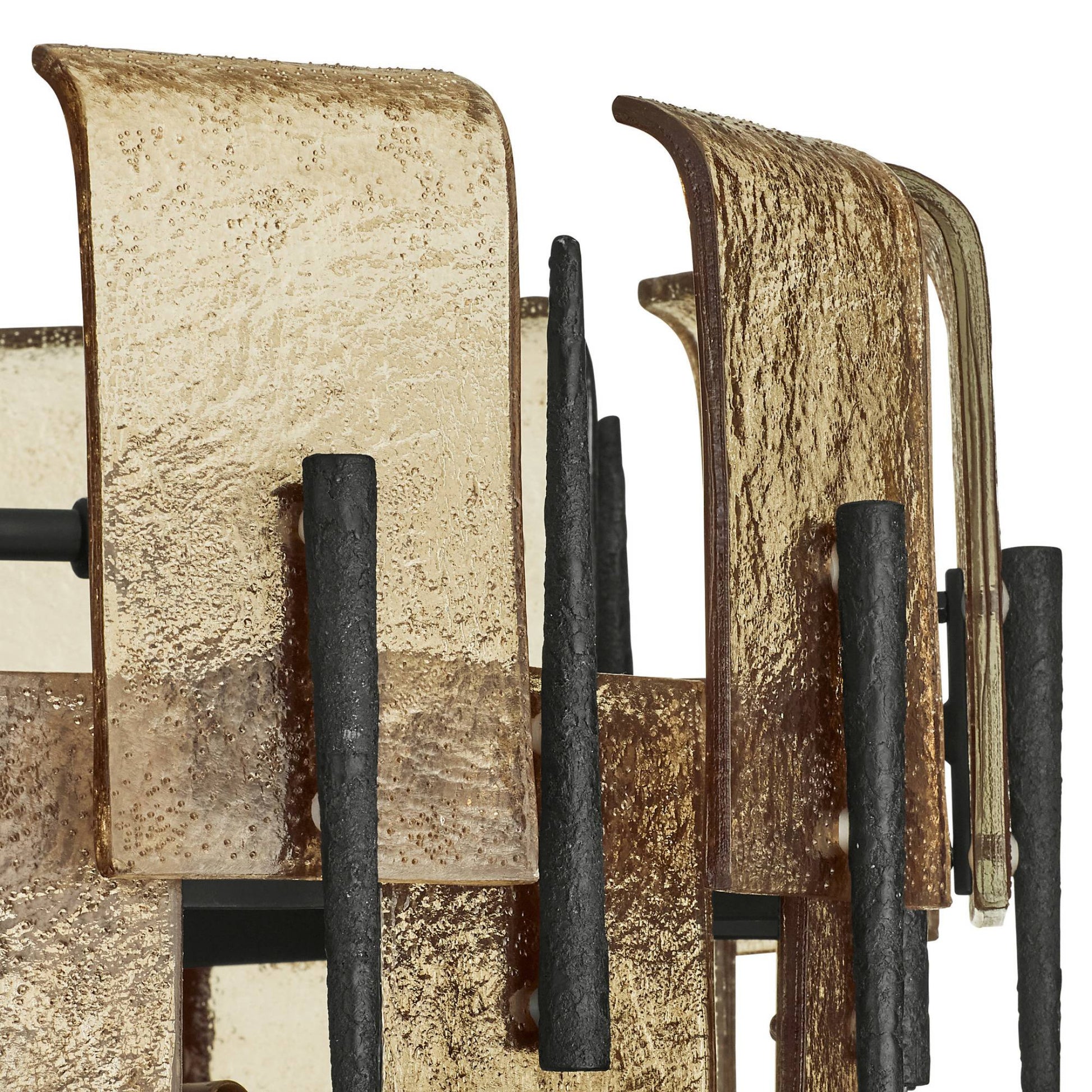 Close-up of a rustic metal wall art piece with textured surfaces and black bars.