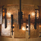 Close-up of a textured metal chandelier with warm lighting.