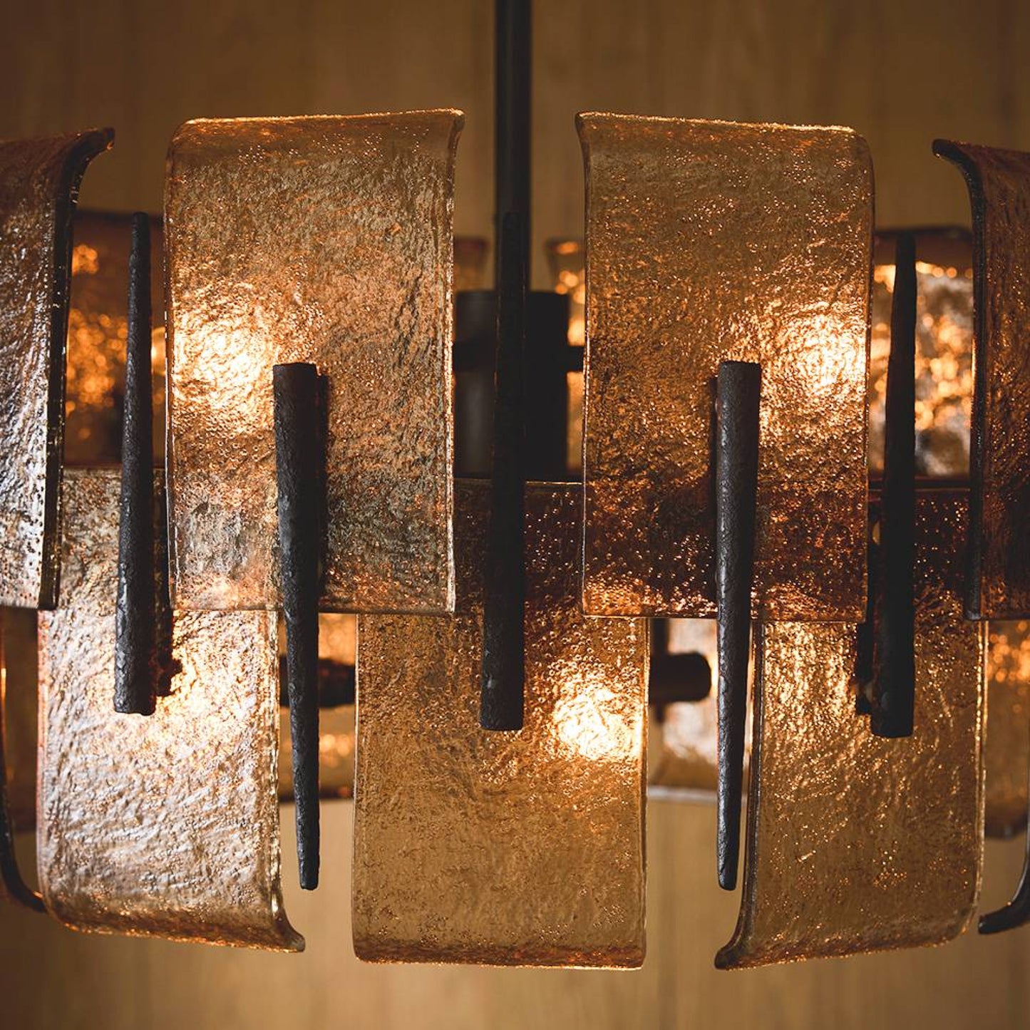 Close-up of a textured metal chandelier with warm lighting.