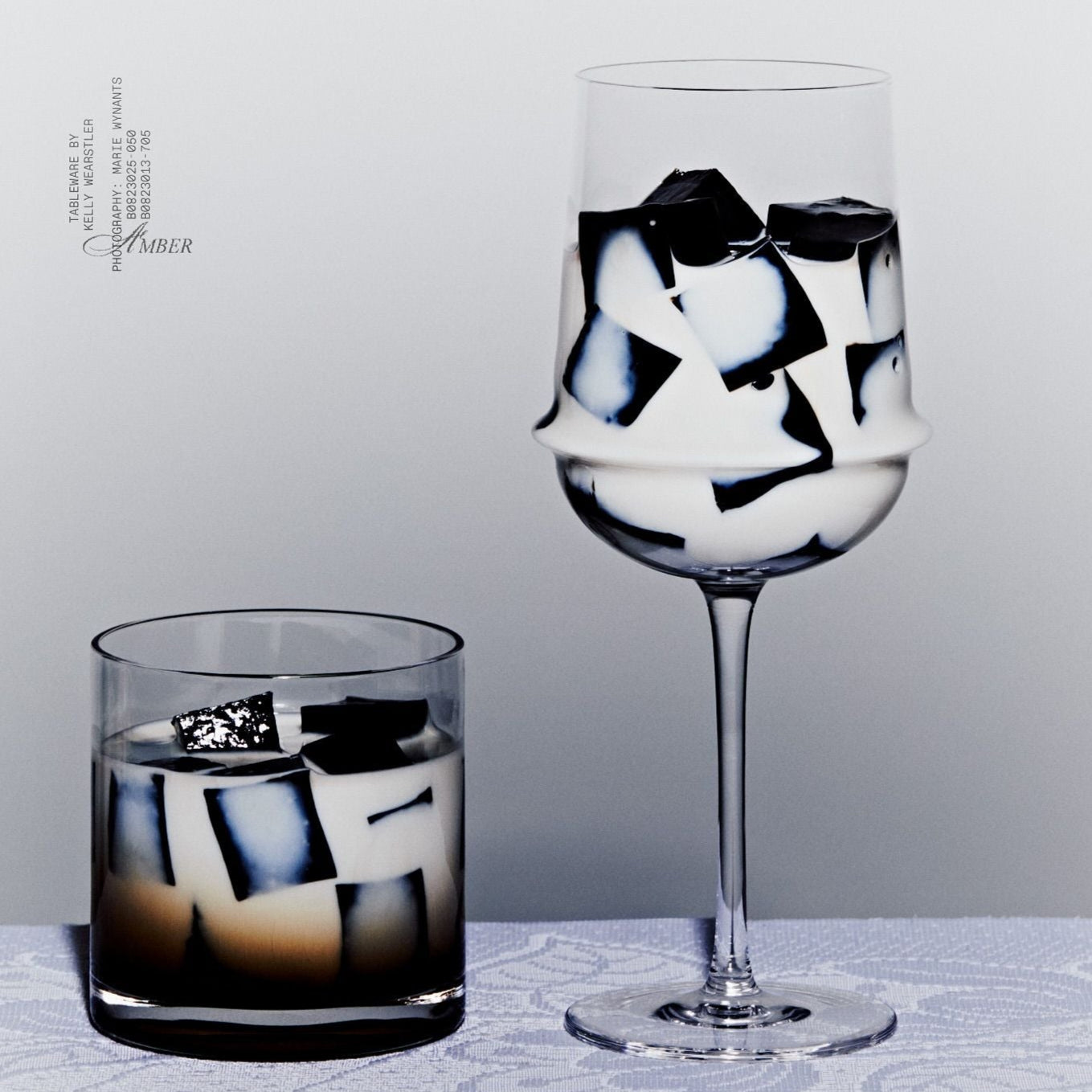 Two glasses with geometric ice cubes on a light gray background
