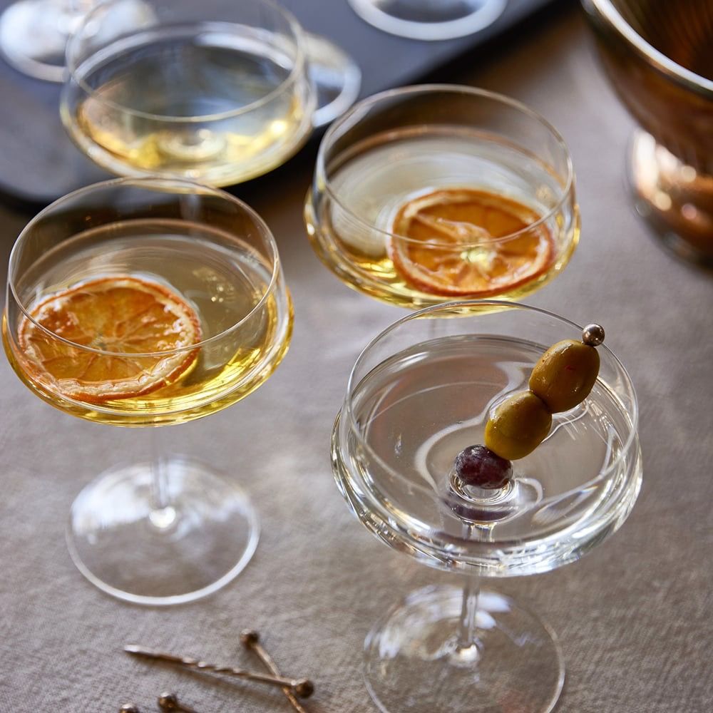 Cocktail glasses with garnishes on a textured surface
