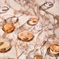 Multiple wine glasses filled with a amber-colored liquid on a marble surface.