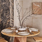 Dining table set with plates, glasses, and cutlery in a modern kitchen.