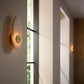Modern wall sconce on a white wall with a window in the background