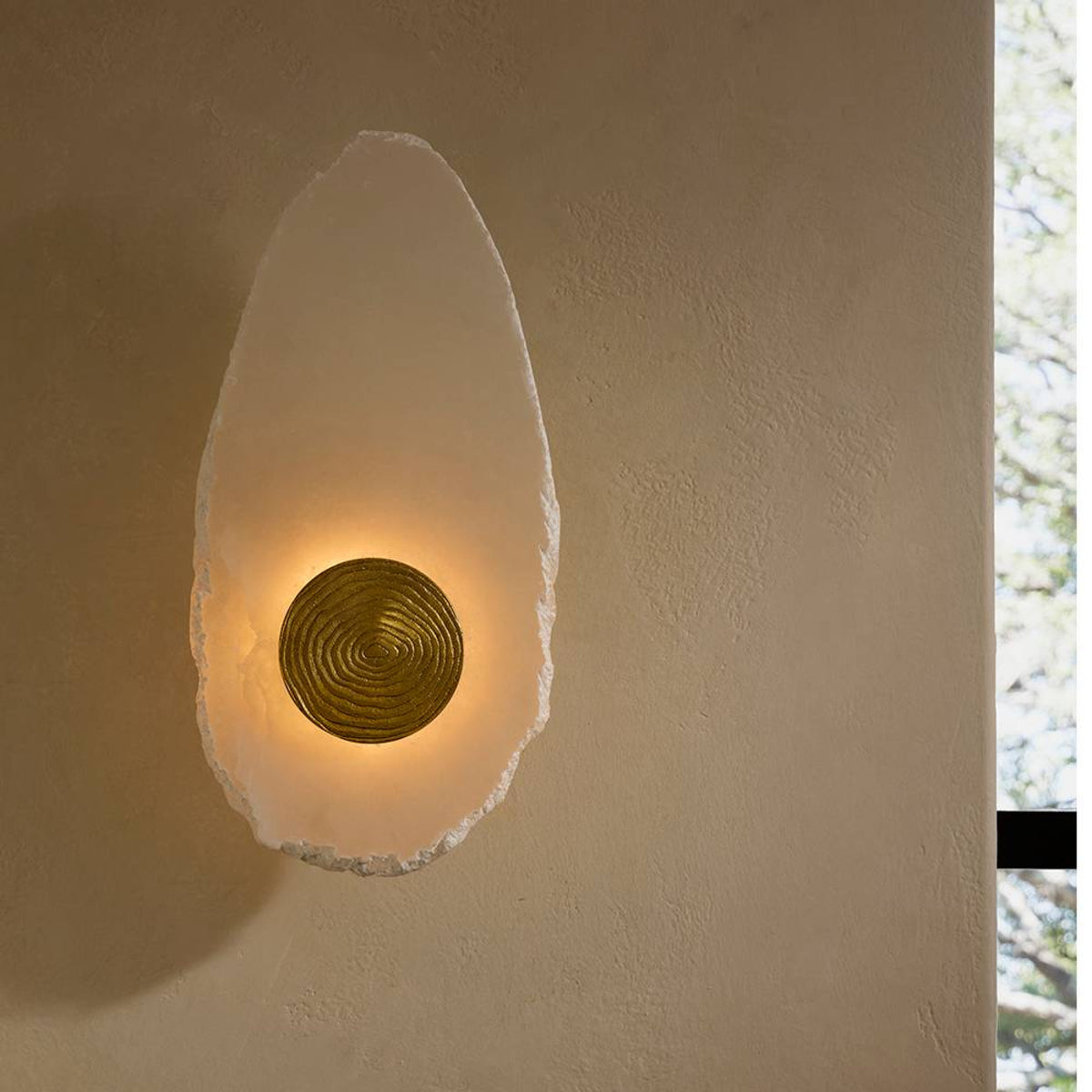 Wall-mounted light fixture with a textured design on a beige wall