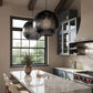 Modern kitchen with marble island, pendant lights, and large window
