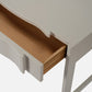 Wooden drawer being pulled out from a white cabinet.