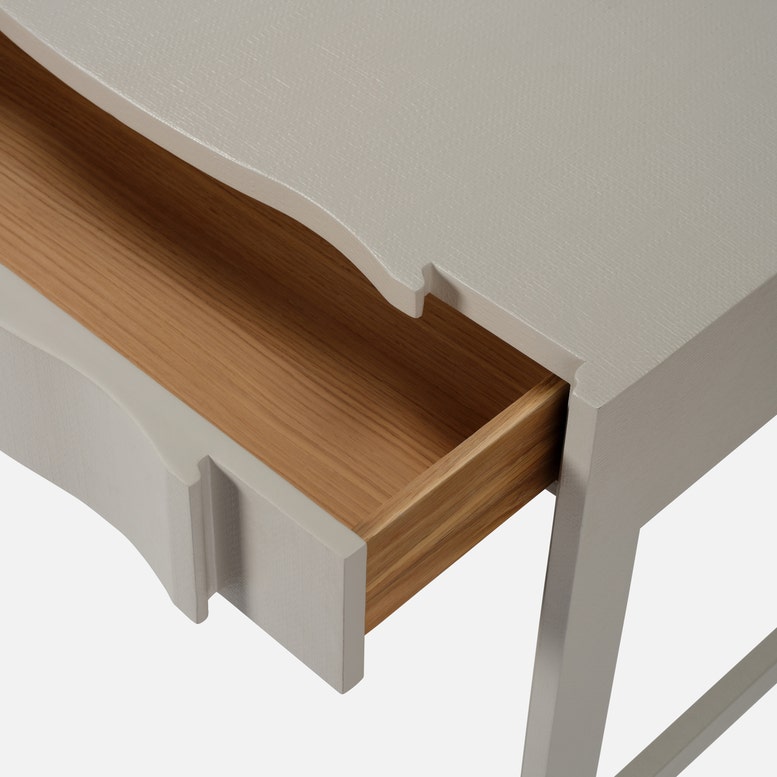 Wooden drawer being pulled out from a white cabinet.