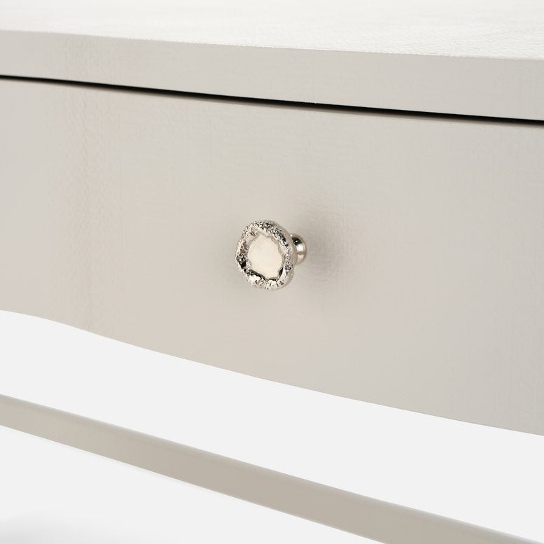 Close-up of a silver knob on a white drawer