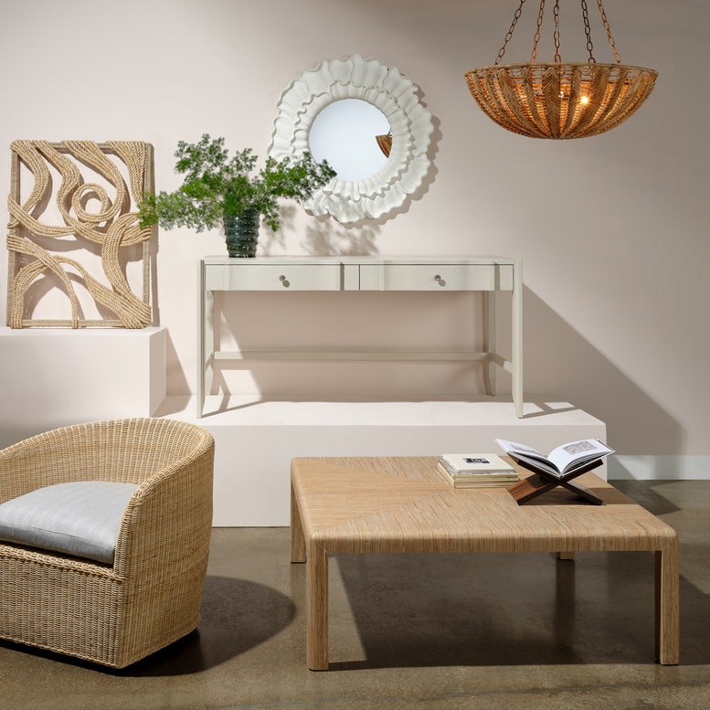 Living room with wicker chair, coffee table, and decorative elements.