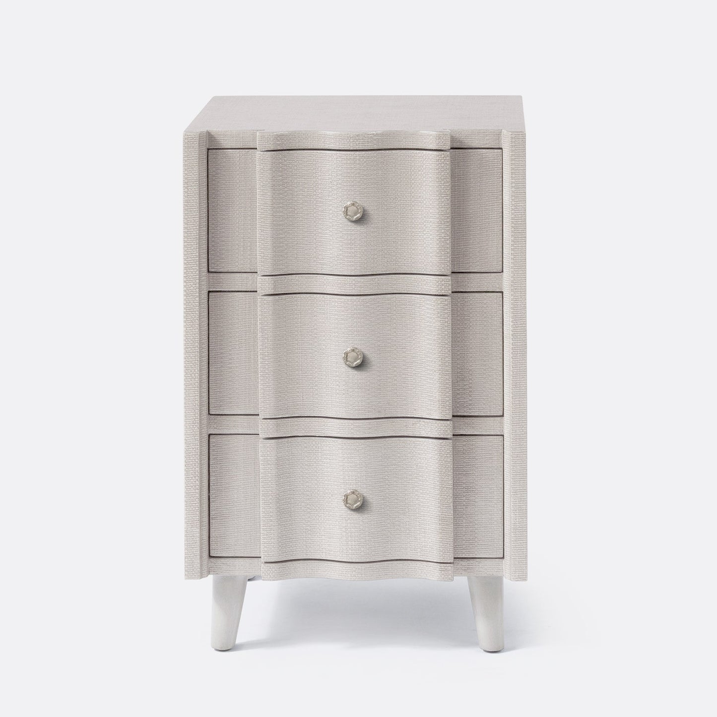 Three-drawer cabinet with textured finish and white legs on a white background