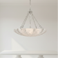 Chandelier with marble-like shade hanging against a white wall
