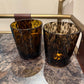 Two tortoiseshell-patterned glasses on a metallic surface.