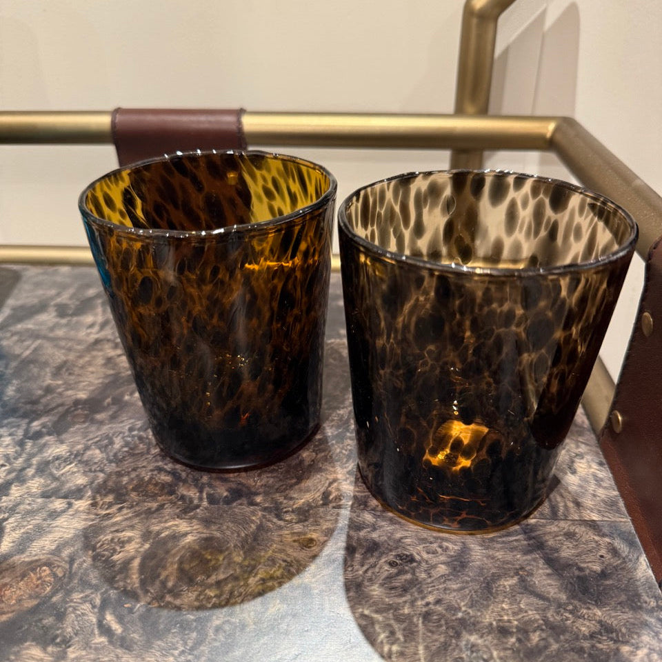 Two tortoiseshell-patterned glasses on a metallic surface.