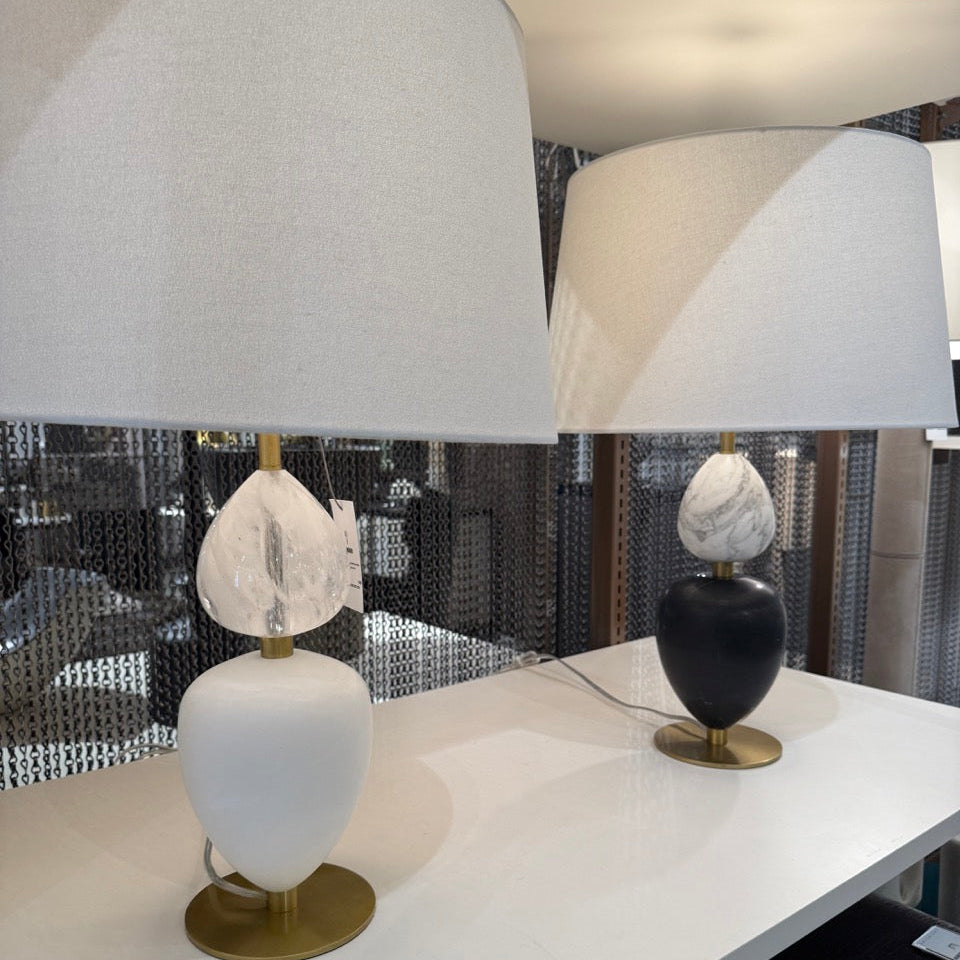 Two table lamps with marble-like tops on a white surface, with a reflective background.