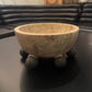 Decorative stone bowl on a dark surface with a blurred background