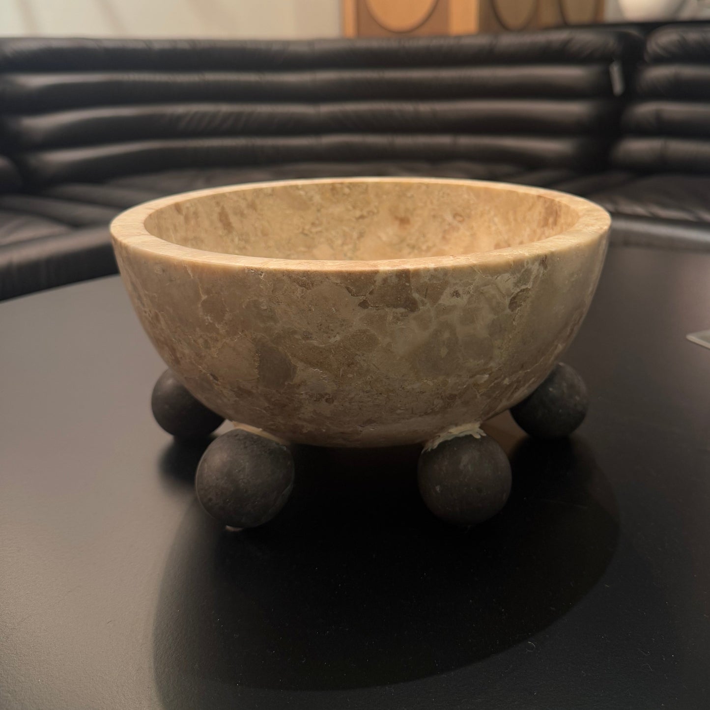 Decorative stone bowl on a dark surface with a blurred background