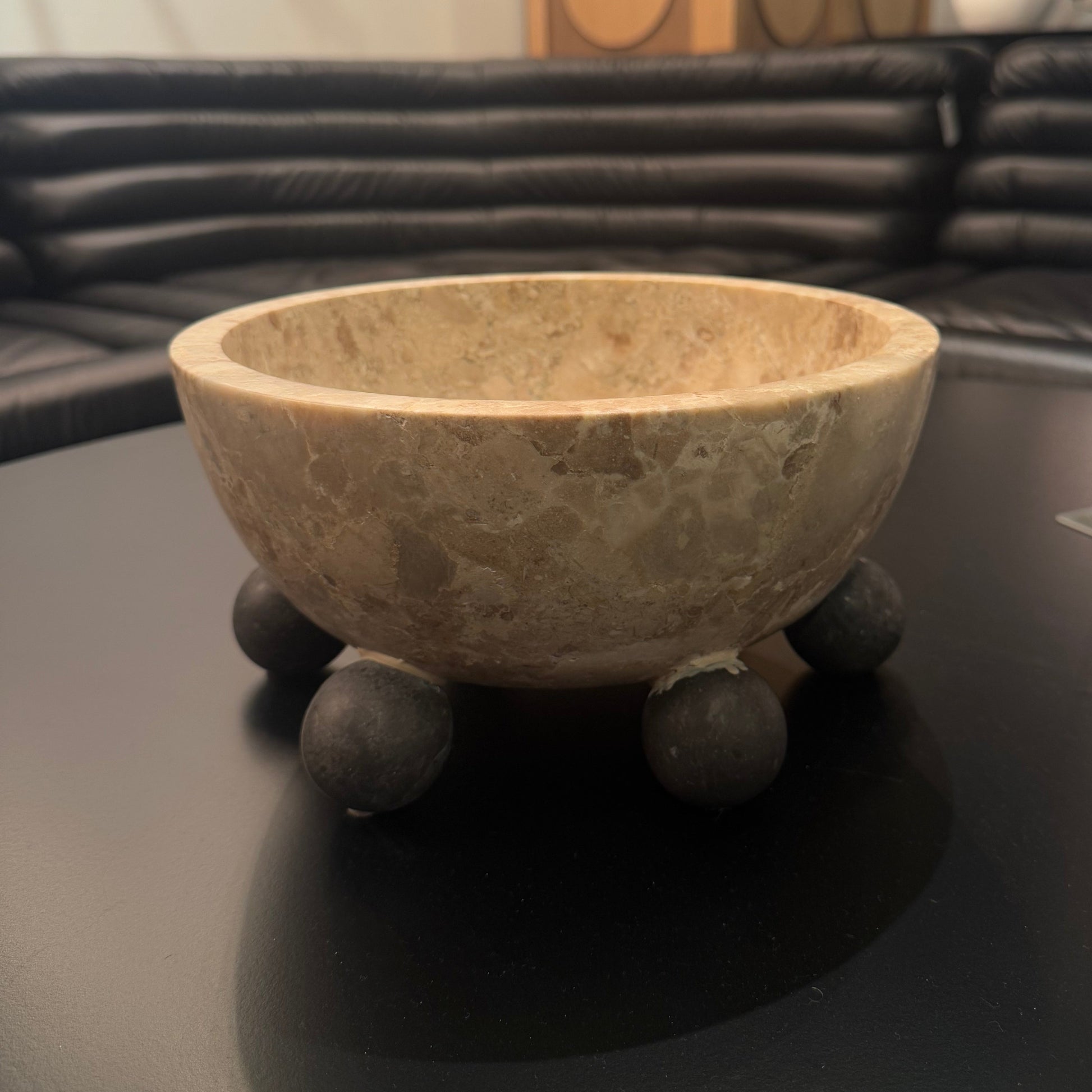 Decorative stone bowl on a dark surface with a blurred background
