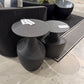 Black side tables with price tags in a showroom setting
