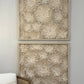 Two framed textured wall art pieces on a gray wall.