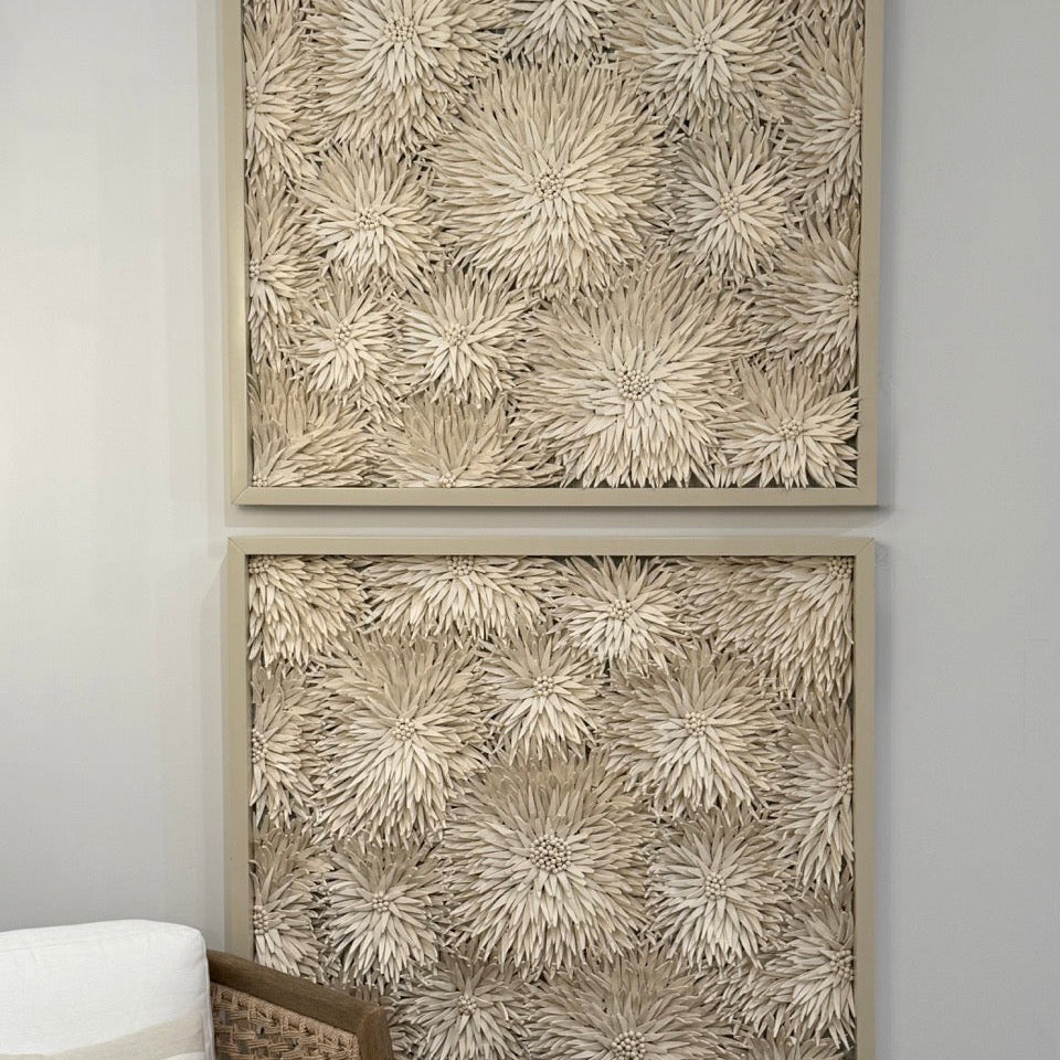 Two framed textured wall art pieces on a gray wall.