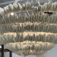 Close-up of a decorative chandelier with a brand tag in the background