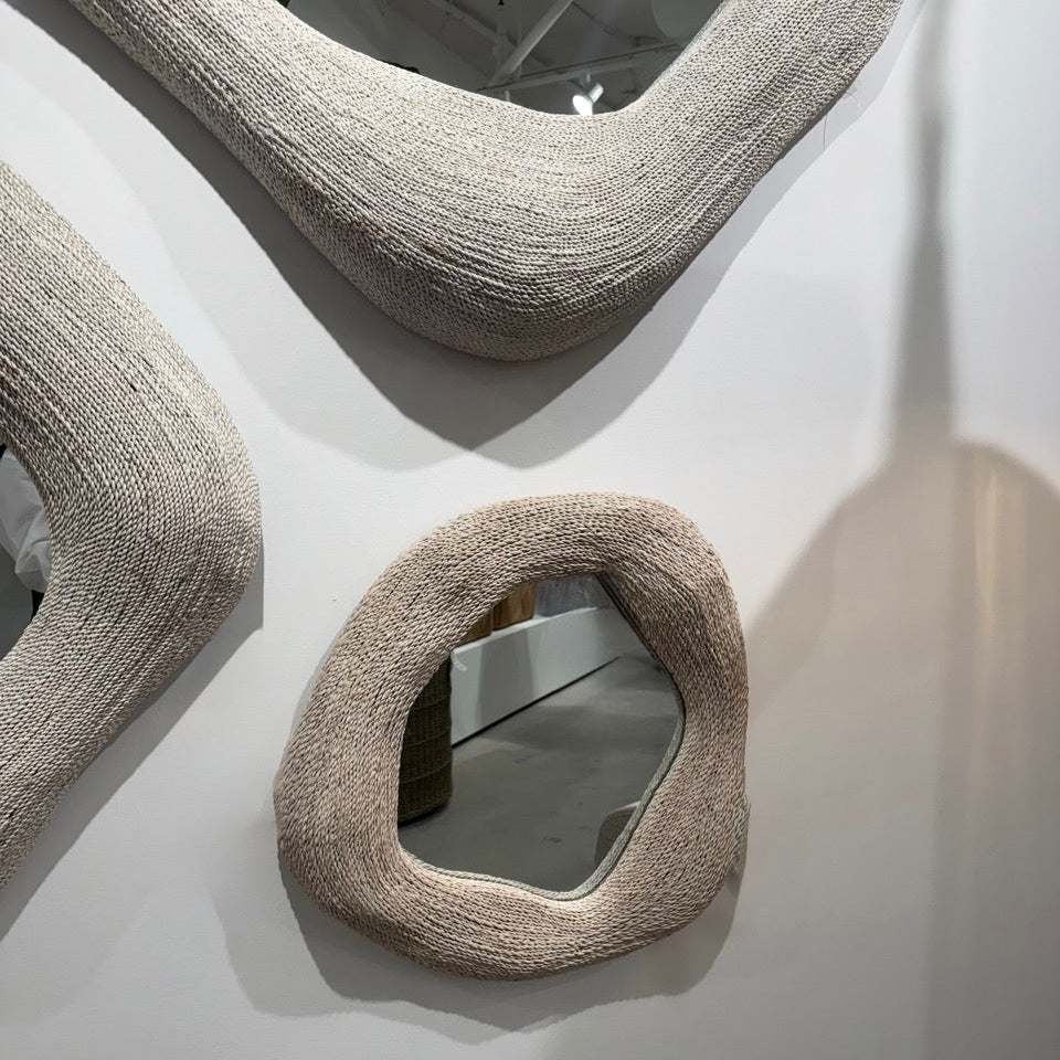 Textured, oval-shaped mirrors on a white wall