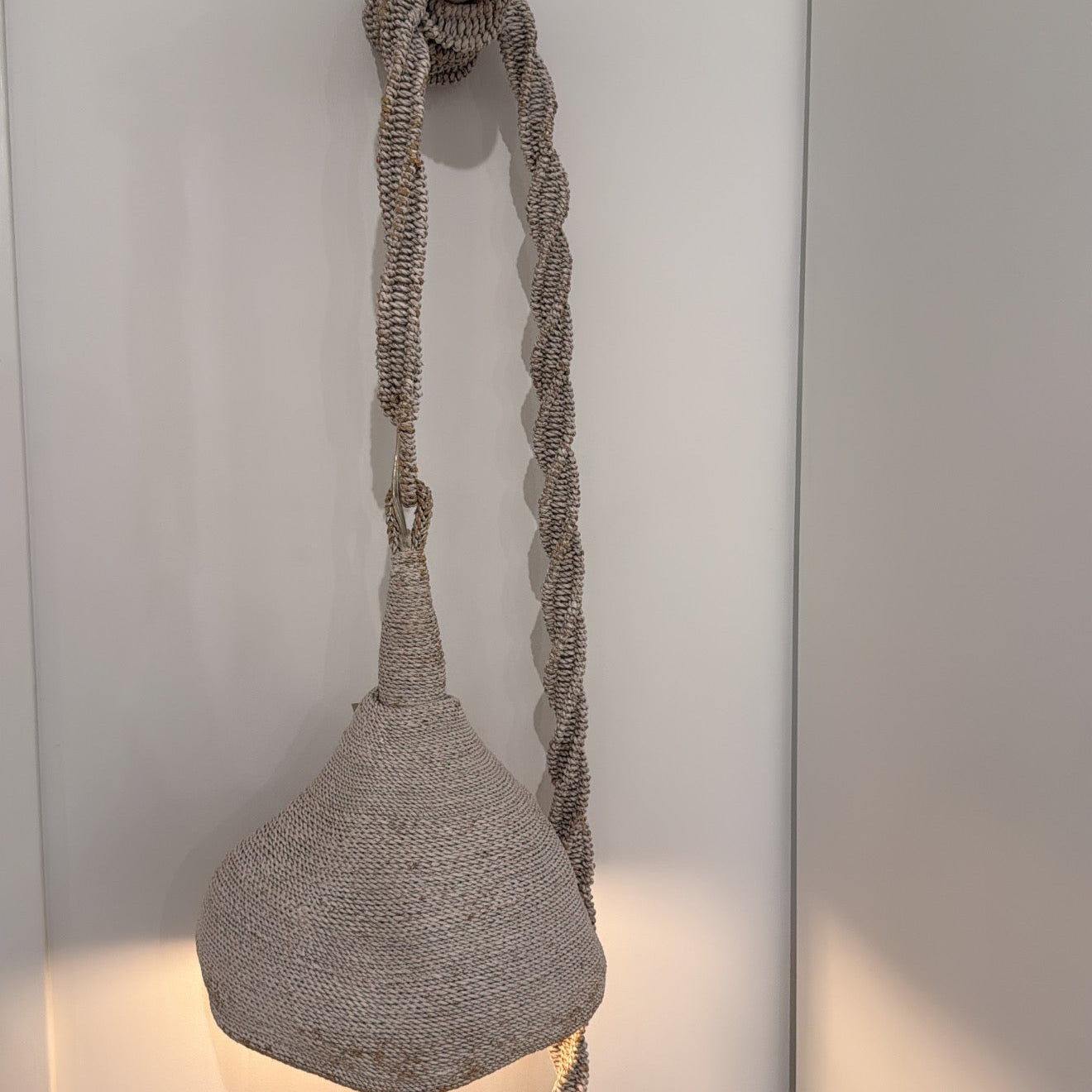 Textured wall light fixture with rope detail on a white wall