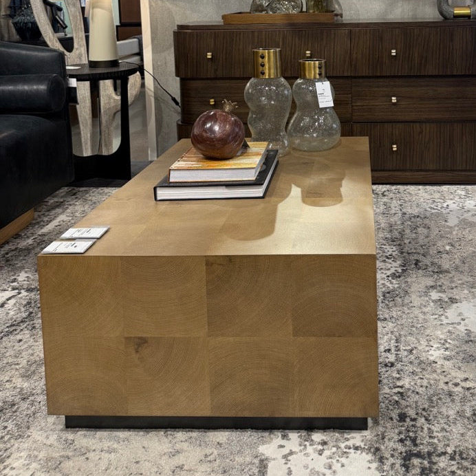 Modern living room with a coffee table, mirror, and lamps in a showroom setting.