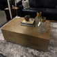 Living room with a wooden coffee table, black sofa, and decorative items.