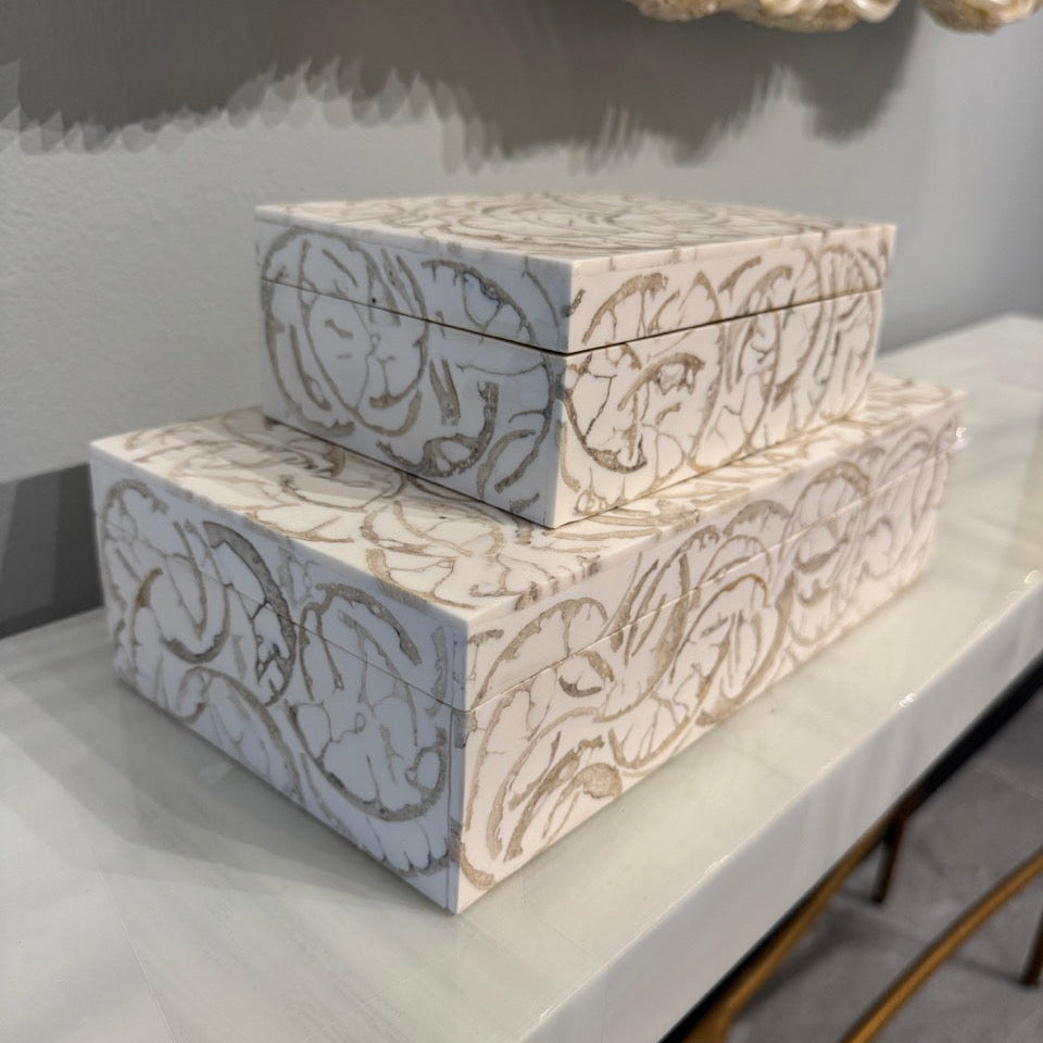 Two decorative boxes with a floral pattern on a white surface.