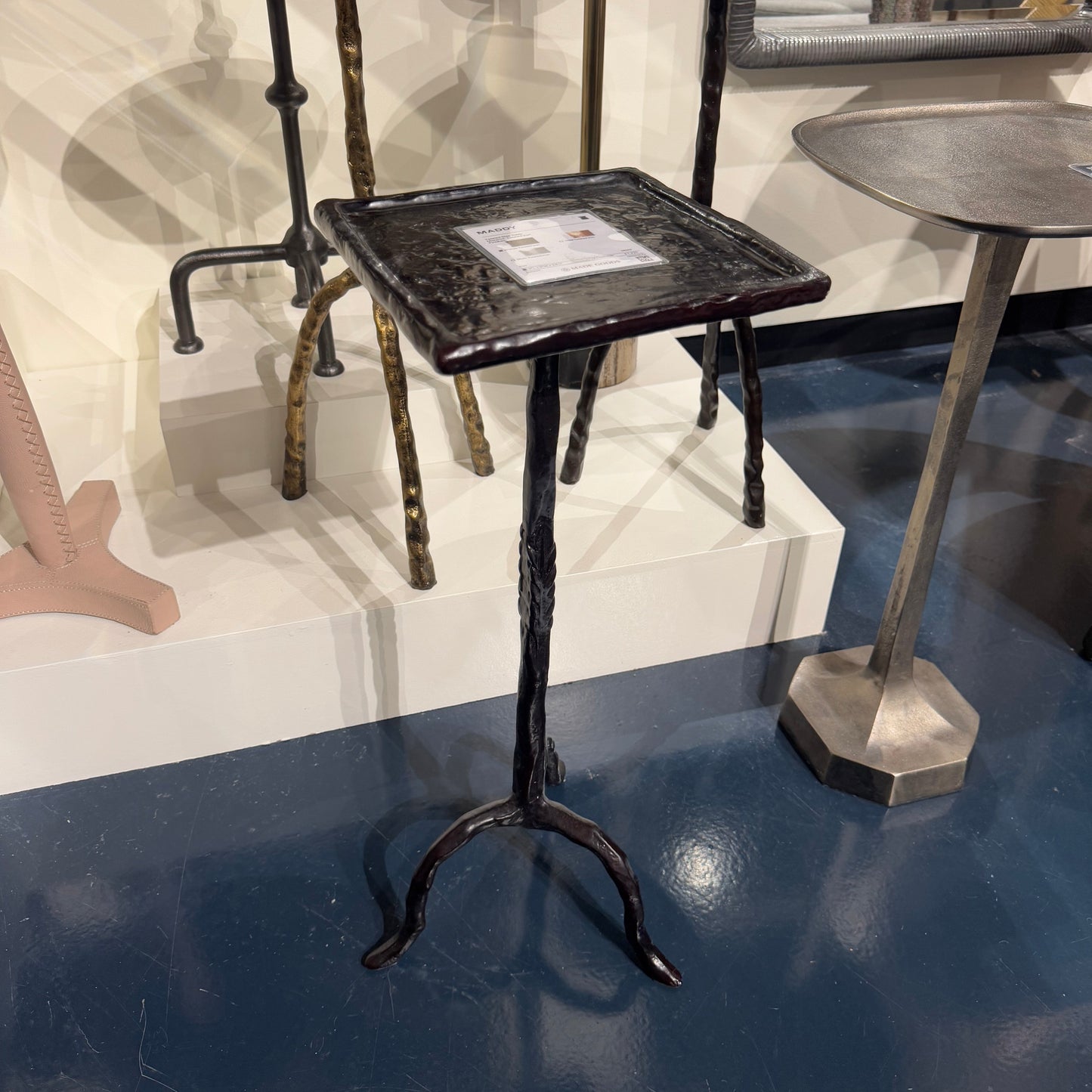 Set of vintage-style metal stools with a dark finish on a reflective surface.