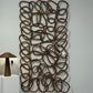 Decorative wall art with interlocking loops on a white wall