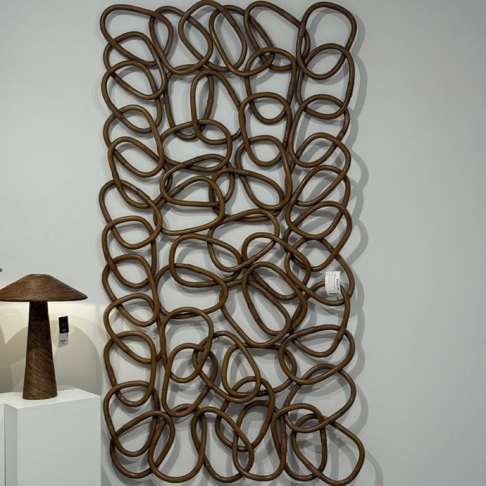 Decorative wall art with interlocking loops on a white wall