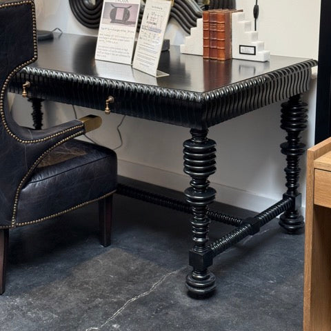 Decorative black table with intricate legs in a showroom setting