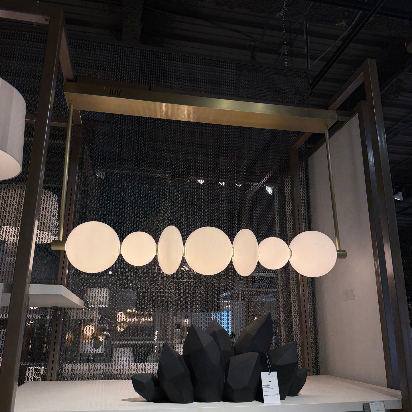 Modern pendant light fixture with circular shades in a darkly lit room.