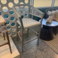 Chair on a balcony with a decorative screen and table in the background