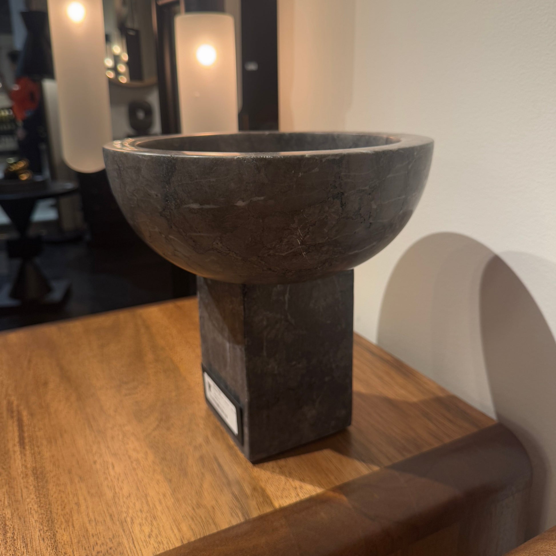 Close-up of a dumbbell on a wooden surface with a mirror reflection.