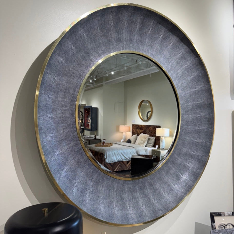 Round wall mirror with decorative frame in a room setting