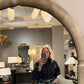 Person taking a mirror selfie in an interior design store with furniture and decor items.
