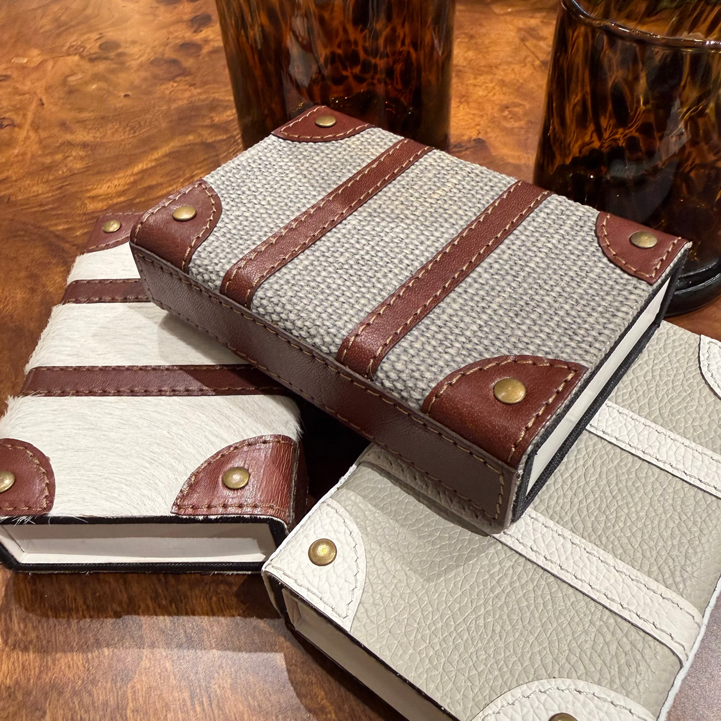 Two leather-bound books with striped design on a wooden surface
