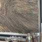 Wooden bar counter with cocktail glasses and shaker against a textured wall.