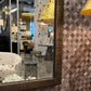Decorative mirror with textured wall and floral table lamps in a room setting