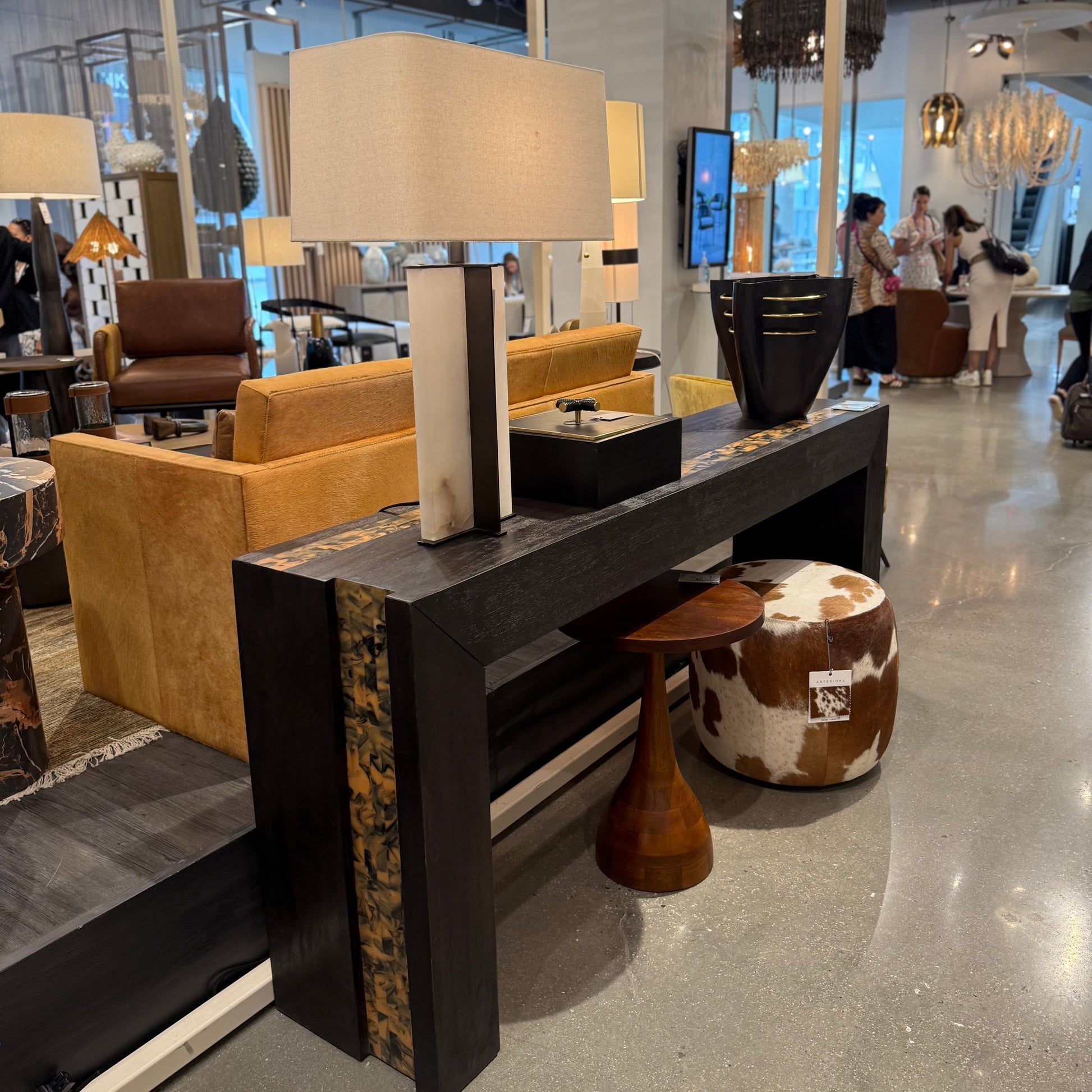 Modern interior design with a console table, lamp, and furniture in a showroom setting.